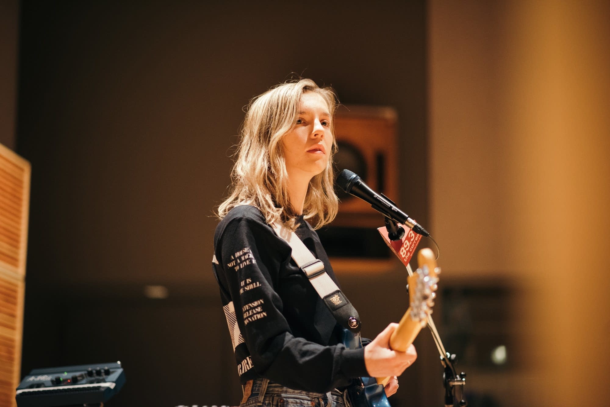 The Japanese House memegang sebuah gitar listrik di sebuah studio